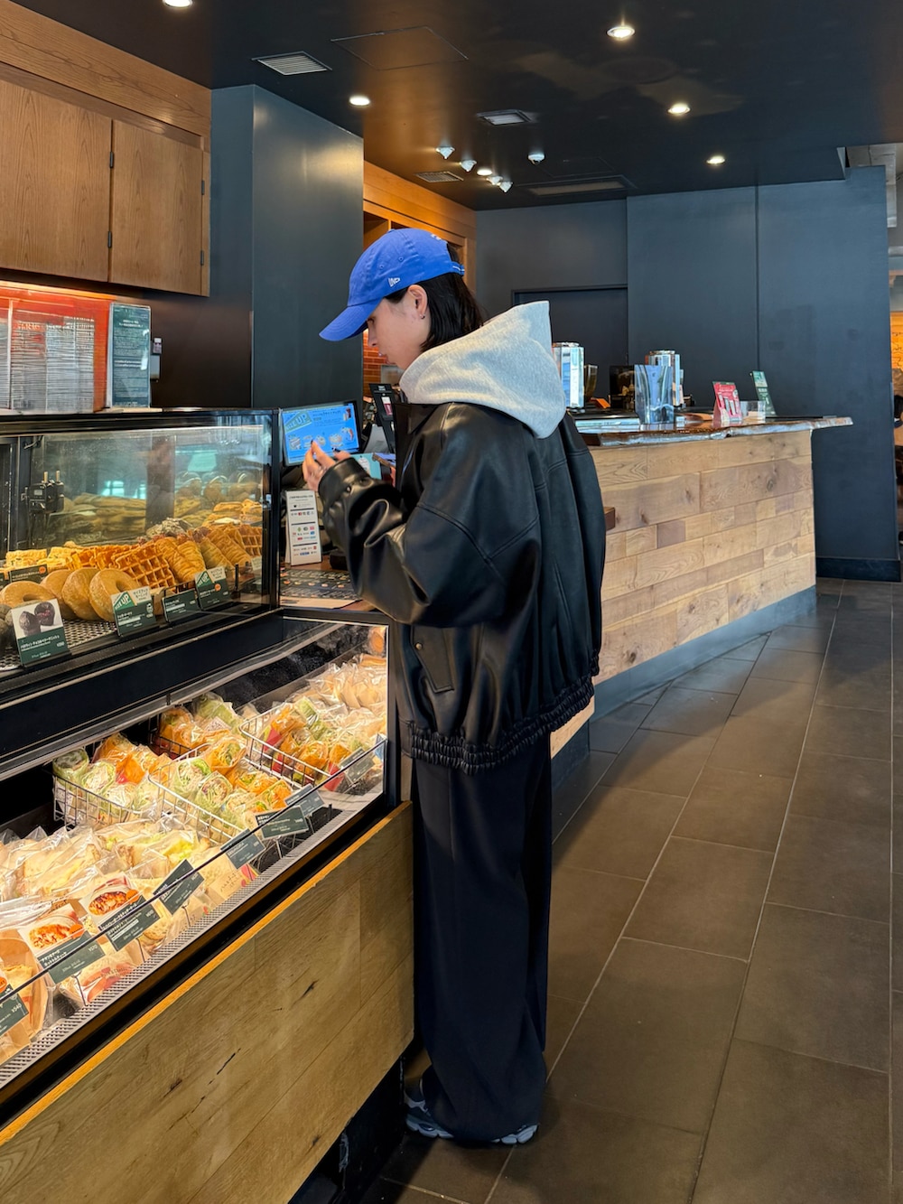 グレー系のパーカー、ブラック系のその他パンツ、ブラック系のブルゾンを着用したレディースの秋コーディネートの3枚目の写真