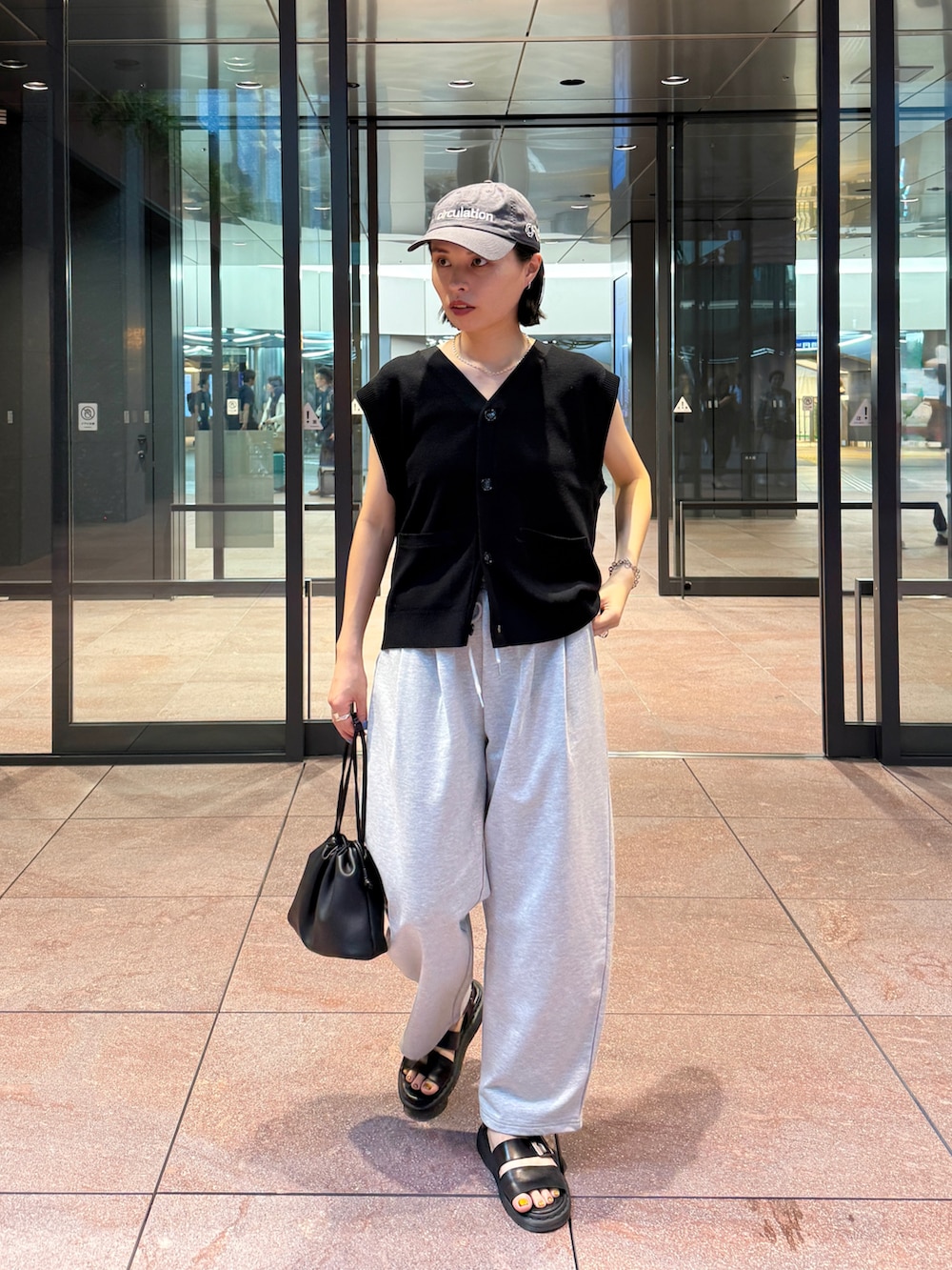 ブラック系のベスト、ブラック系のショルダーバッグを着用したレディースの秋コーディネートの3枚目の写真