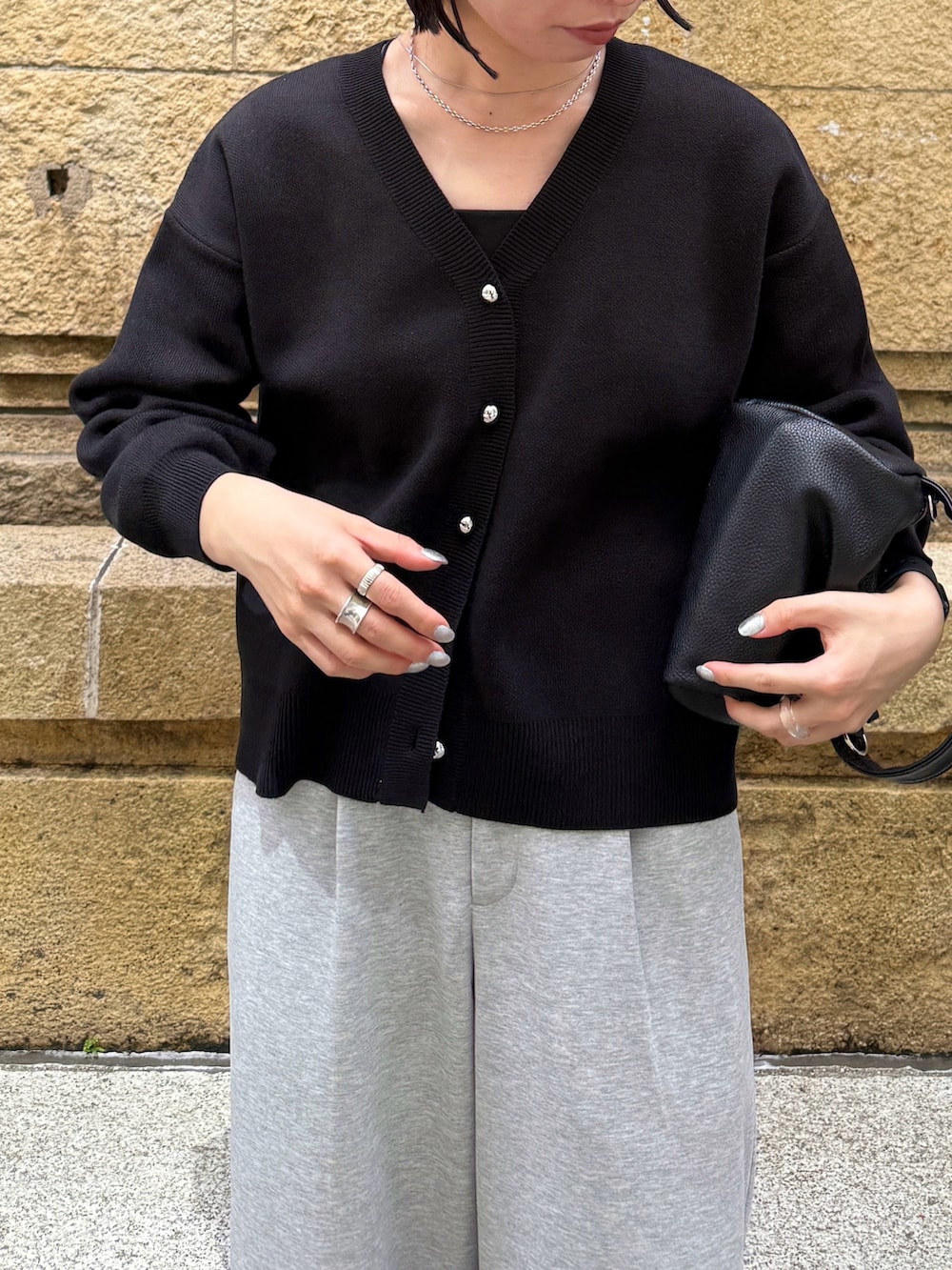 ブラック系のカーディガン/ボレロ、グレー系のパンツ、ブラック系のショルダーバッグを着用したレディースの秋コーディネートの3枚目の写真