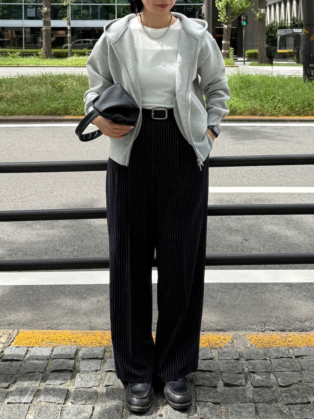 グレー系のパーカー、ホワイト系のTシャツ/カットソー、ブルー系のスラックスを着用したレディースの秋コーディネートの3枚目の写真