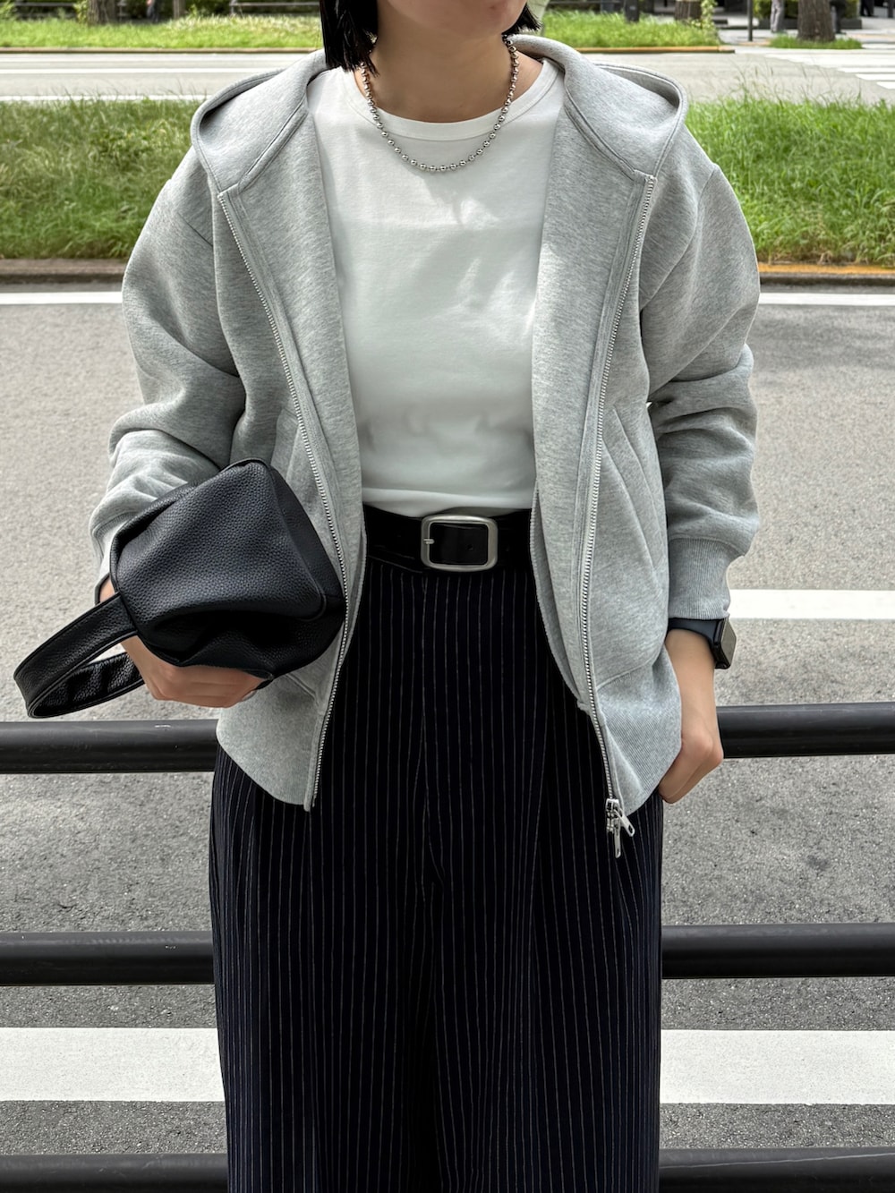 グレー系のパーカー、ホワイト系のTシャツ/カットソー、ブルー系のスラックスを着用したレディースの秋コーディネートの2枚目の写真