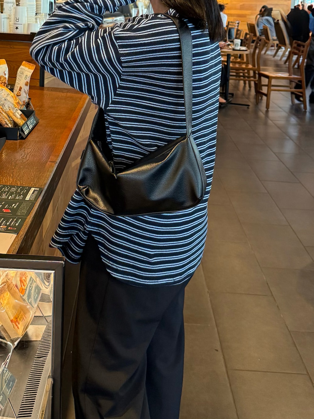 ブラック系のショルダーバッグ、ブラック系のその他パンツ、ブルー系のTシャツ/カットソーを着用したレディースの秋コーディネートの4枚目の写真
