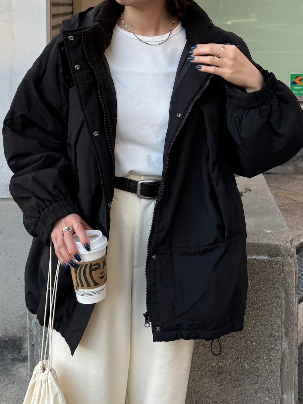 ブラック系のダウンジャケット/コート、ホワイト系のTシャツ/カットソー、ホワイト系のその他パンツを着用したレディースの秋コーディネートの2枚目の写真