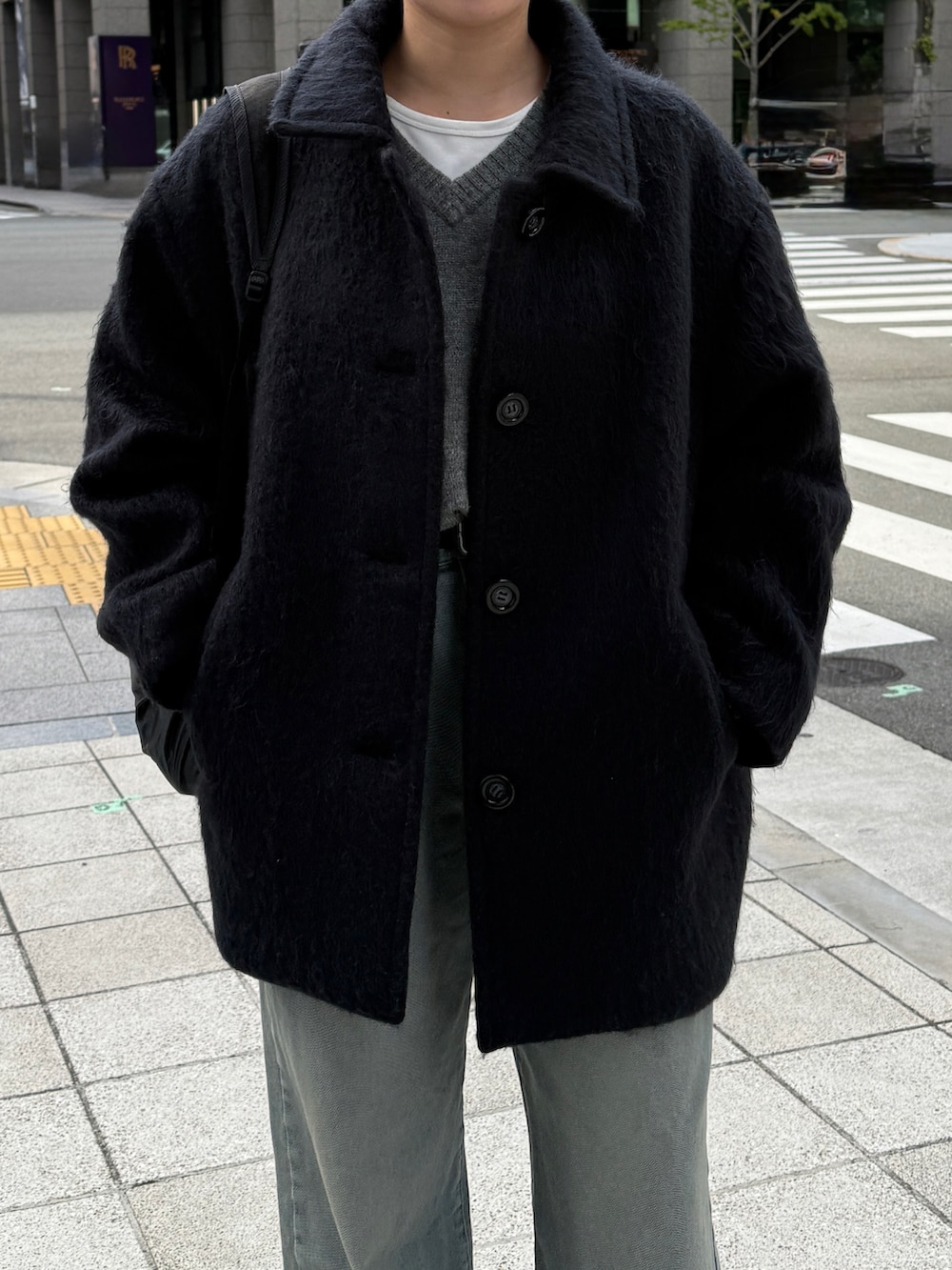 グレー系のニット/セーター、グレー系のジャケット/アウター、ブルー系のデニムパンツを着用したレディースの冬コーディネートの2枚目の写真
