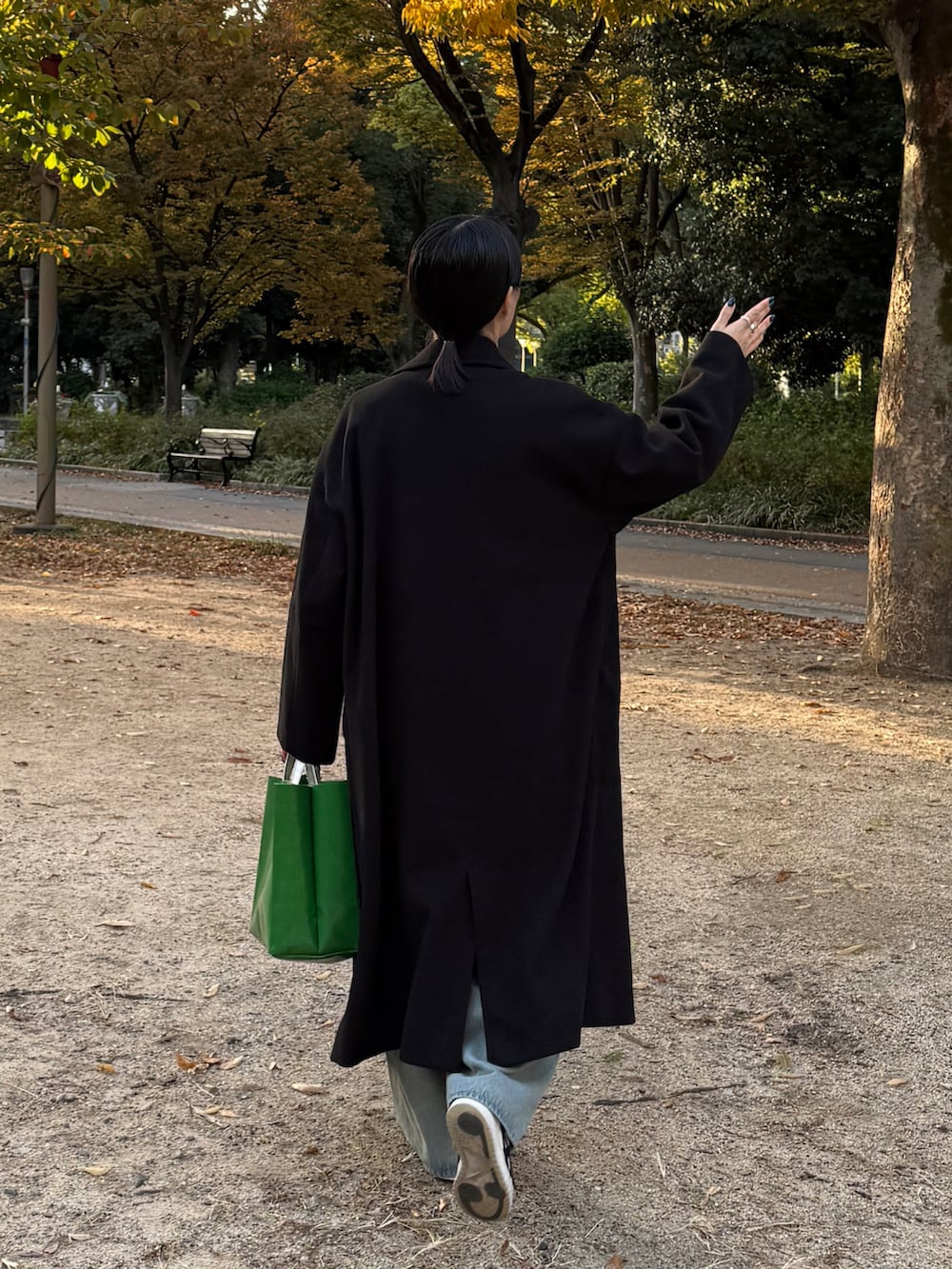 ブラック系のチェスターコート、グレー系のTシャツ/カットソー、ブルー系のデニムパンツを着用したレディースの冬コーディネートの5枚目の写真