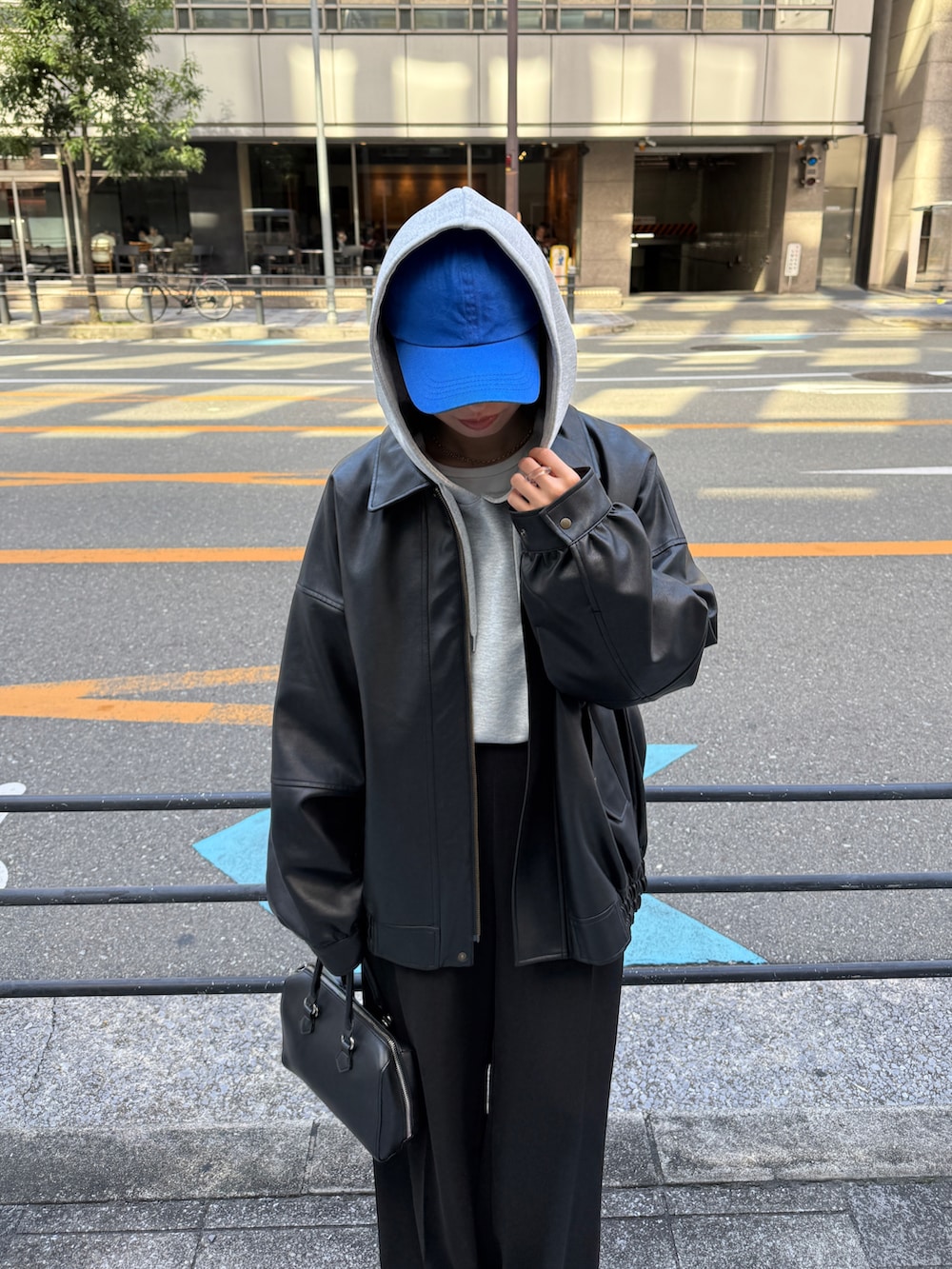 グレー系のパーカー、ブラック系のその他パンツ、ブラック系のブルゾンを着用したレディースの秋コーディネートの2枚目の写真