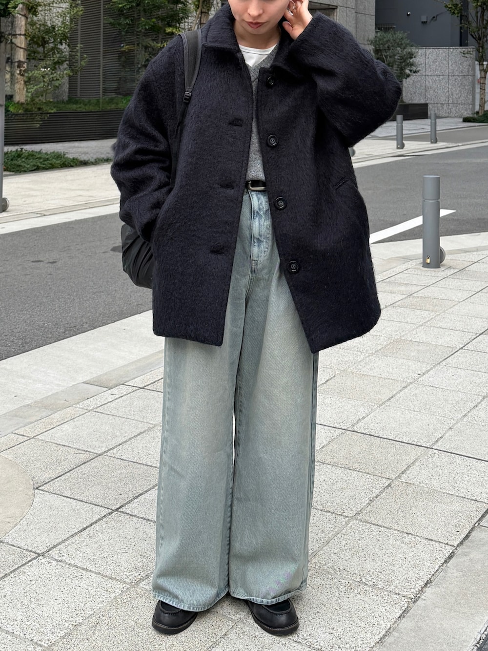 グレー系のニット/セーター、グレー系のジャケット/アウター、ブルー系のデニムパンツを着用したレディースの冬コーディネートの3枚目の写真