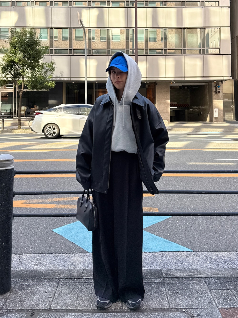 グレー系のパーカー、ブラック系のその他パンツ、ブラック系のブルゾンを着用したレディースの秋コーディネートの5枚目の写真