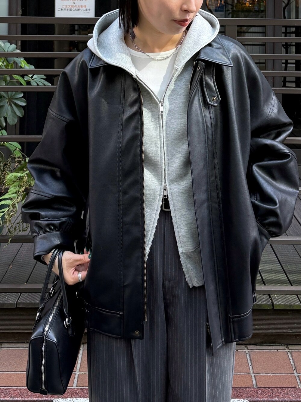 ホワイト系のTシャツ/カットソー、グレー系のパーカー、ブラック系のブルゾンを着用したレディースの秋コーディネートの2枚目の写真