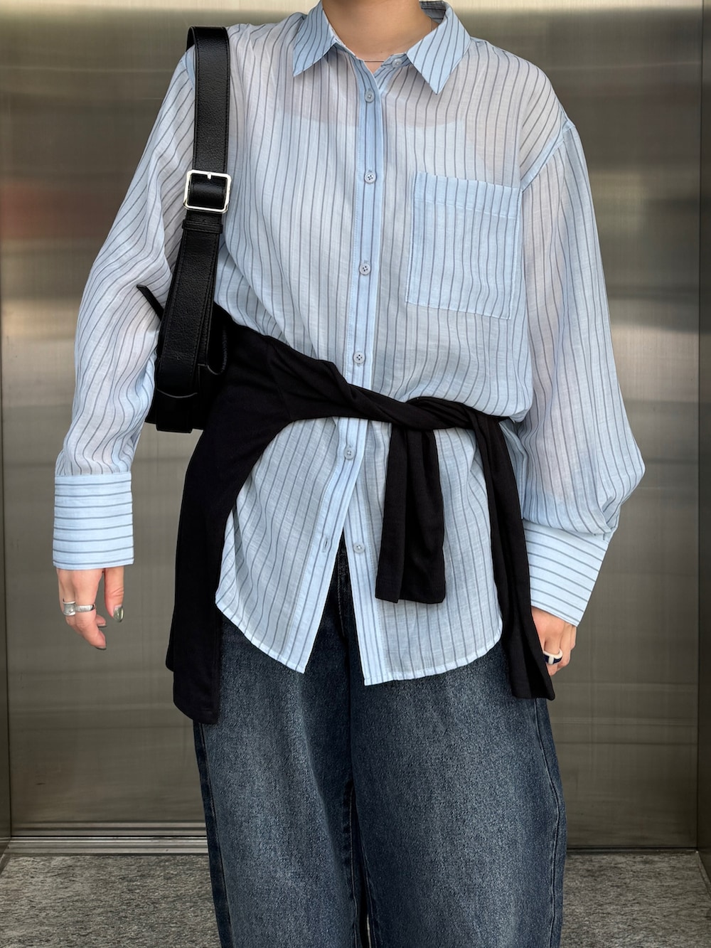 ブルー系のシャツ/ブラウス、ブラック系のTシャツ/カットソー、ブラック系のショルダーバッグを着用したレディースの秋コーディネートの2枚目の写真