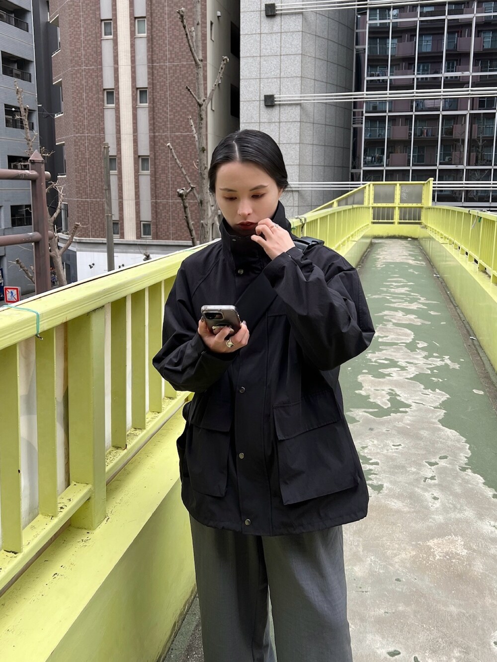 ブラック系のマウンテンパーカー、グレー系のその他パンツを着用したレディースの春コーディネートの2枚目の写真