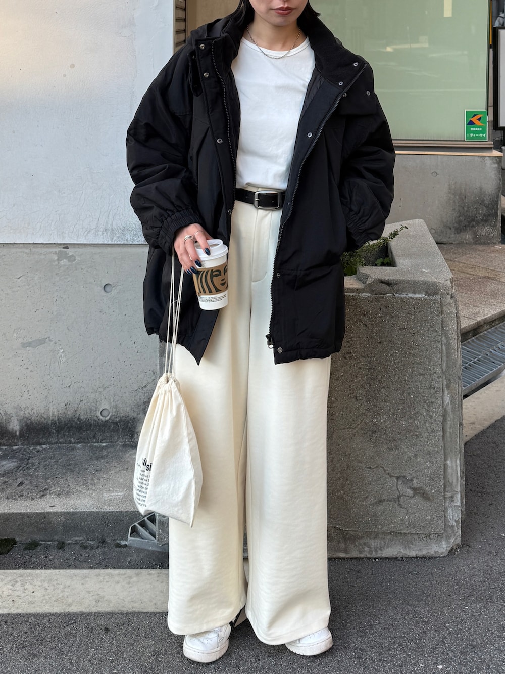 ブラック系のダウンジャケット/コート、ホワイト系のTシャツ/カットソー、ホワイト系のその他パンツを着用したレディースの秋コーディネートの3枚目の写真