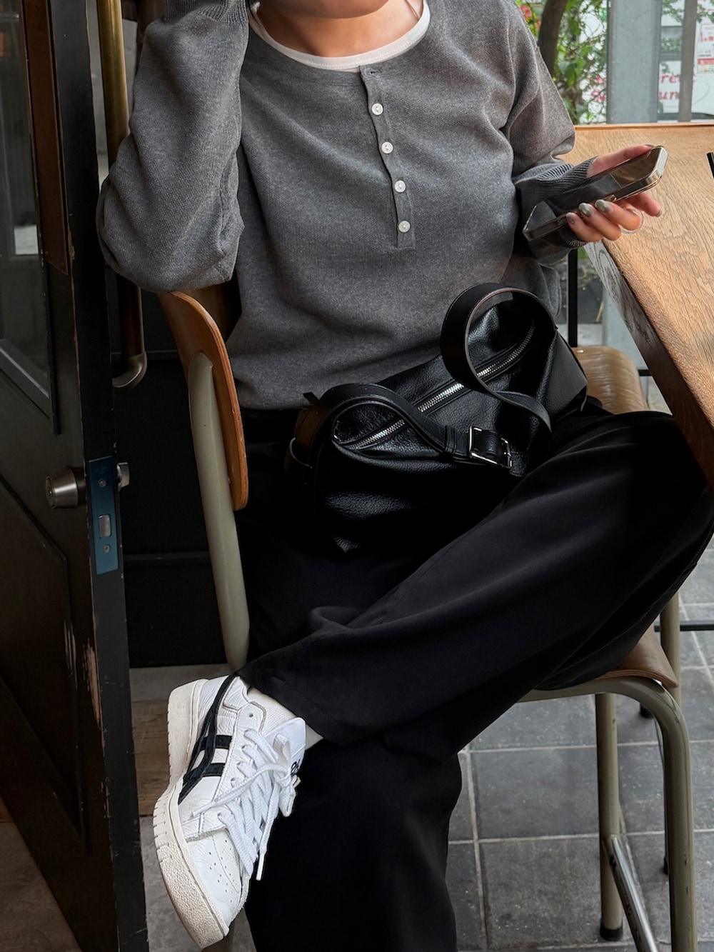 グレー系のニット/セーター、ブラック系のTシャツ/カットソー、ブラック系のショルダーバッグを着用したレディースの秋コーディネートの5枚目の写真