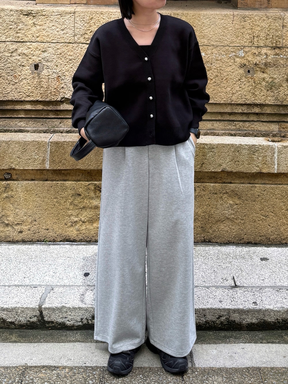 ブラック系のカーディガン/ボレロ、グレー系のパンツ、ブラック系のショルダーバッグを着用したレディースの秋コーディネートの2枚目の写真