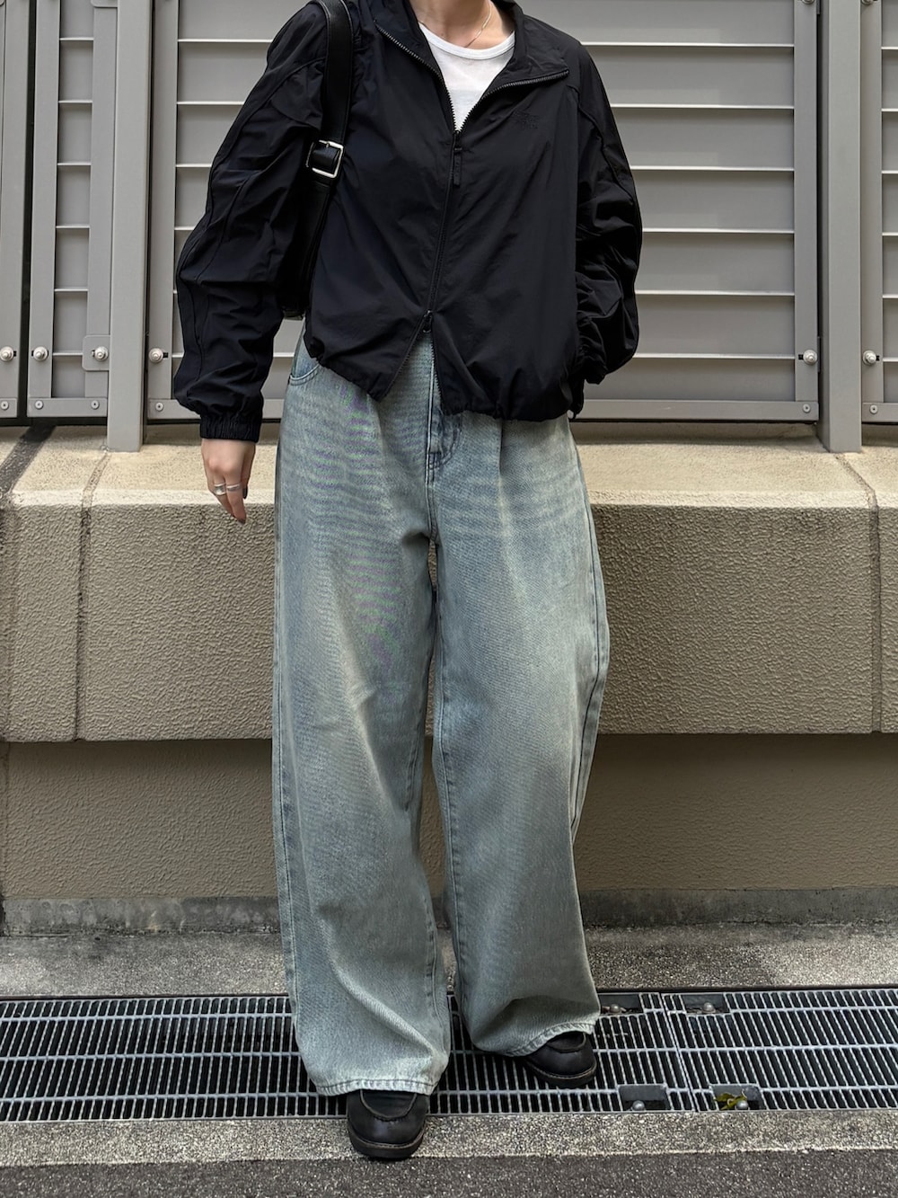 グレー系のTシャツ/カットソー、ブラック系のブルゾン、ブラック系のショルダーバッグを着用したレディースの秋コーディネートの3枚目の写真