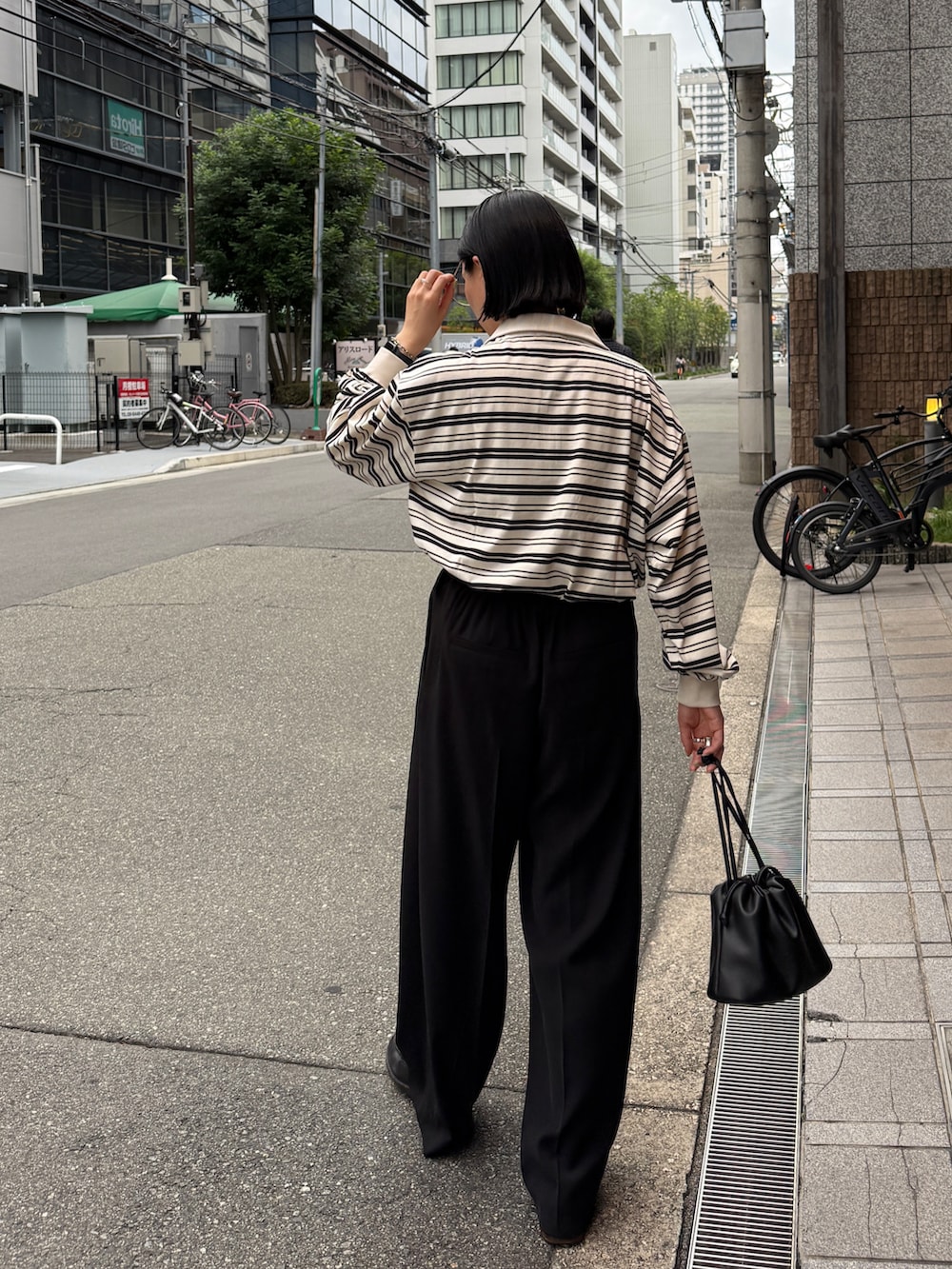 ホワイト系のTシャツ/カットソー、ブラック系のその他パンツ、ブラック系のショルダーバッグを着用したレディースの秋コーディネートの4枚目の写真