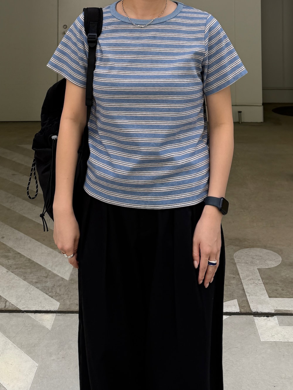 ブルー系のTシャツ/カットソー、ブラック系のスラックス、ブラック系のバックパック/リュックを着用したレディースの秋コーディネートの2枚目の写真