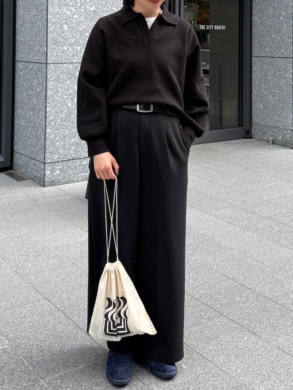 ブラック系のニット/セーター、ブラック系のその他パンツ、ホワイト系のTシャツ/カットソーを着用したレディースの秋コーディネートの2枚目の写真