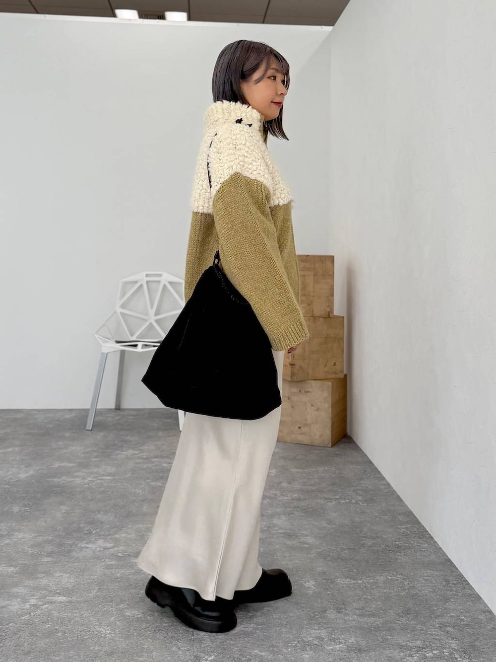 ホワイト系のスカート、ブラック系のサンダル、ブラック系のトートバッグを着用したレディースの秋コーディネートの3枚目の写真