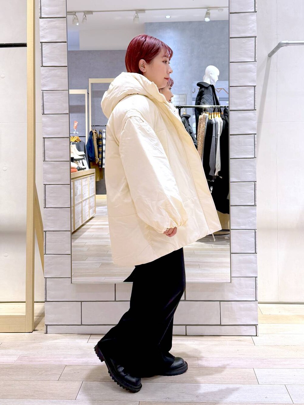 ホワイト系のその他アウター、ブラック系のその他パンツ、ブラック系のニット/セーターを着用したレディースの冬コーディネートの3枚目の写真