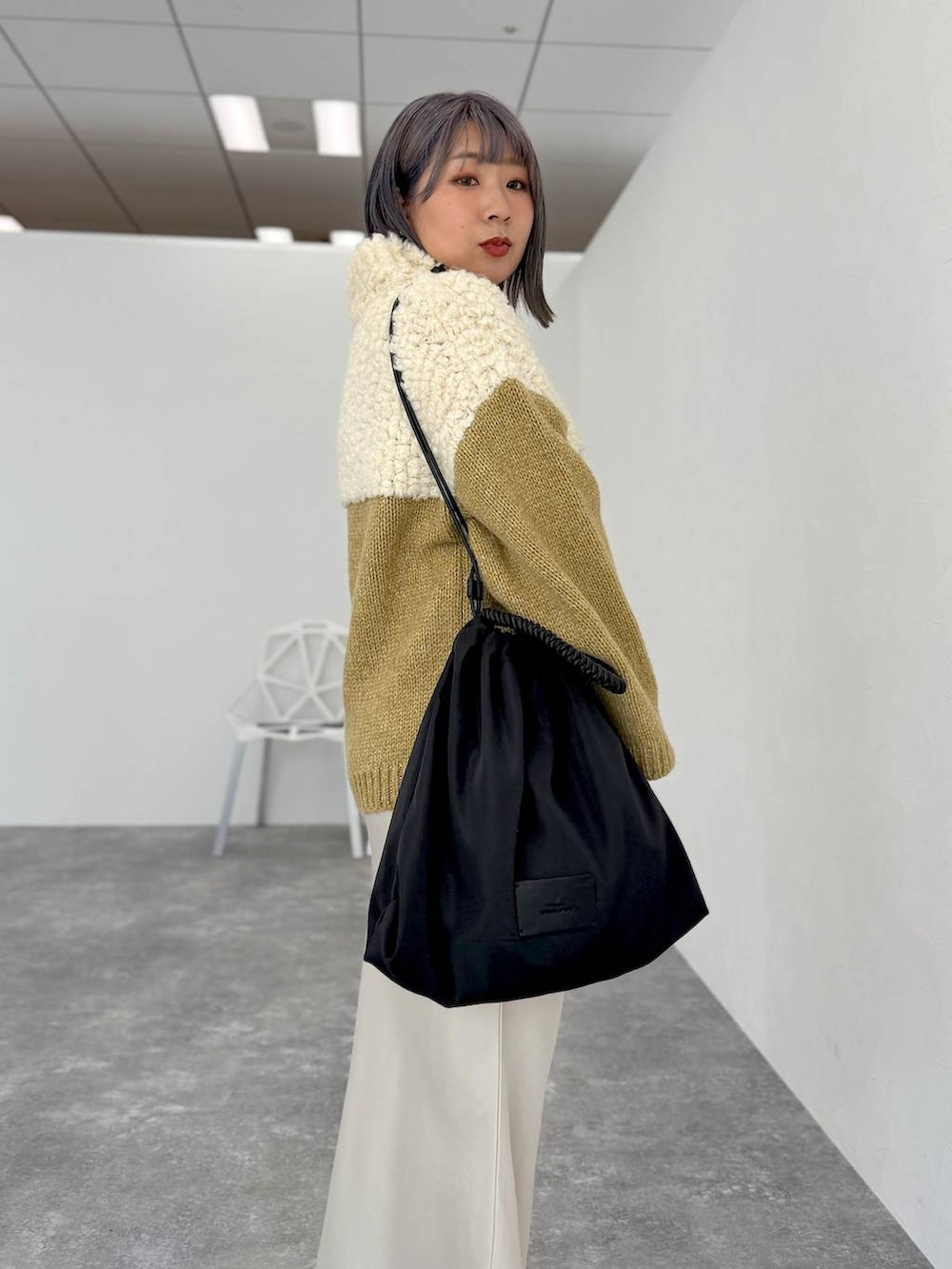 ホワイト系のスカート、ブラック系のサンダル、ブラック系のトートバッグを着用したレディースの秋コーディネートの2枚目の写真