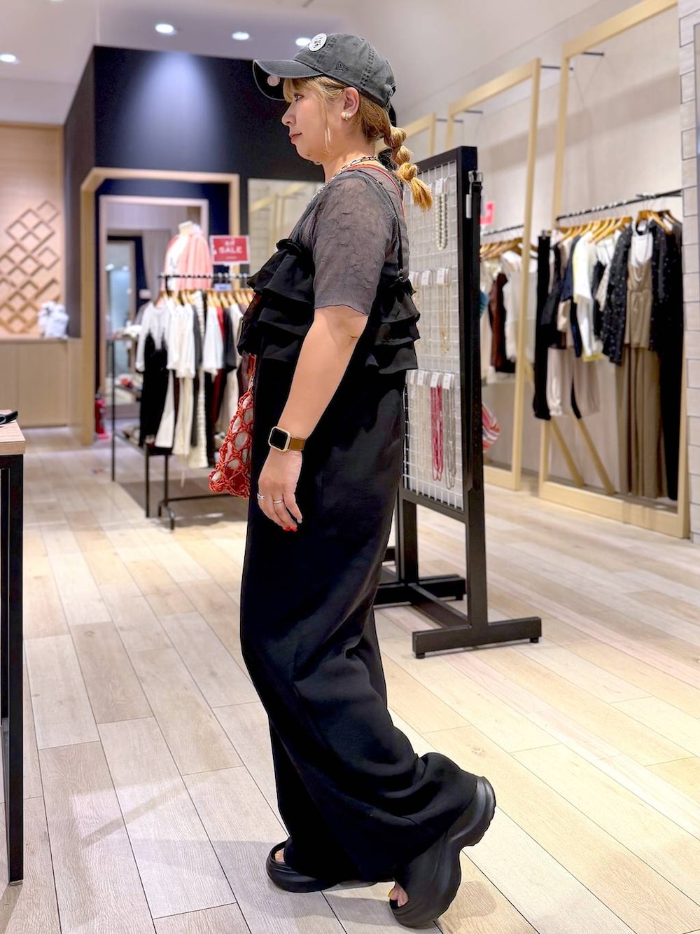 オレンジ系のハンドバッグ、ブラック系のサンダル、グレー系のTシャツ/カットソーを着用したレディースの夏コーディネートの5枚目の写真