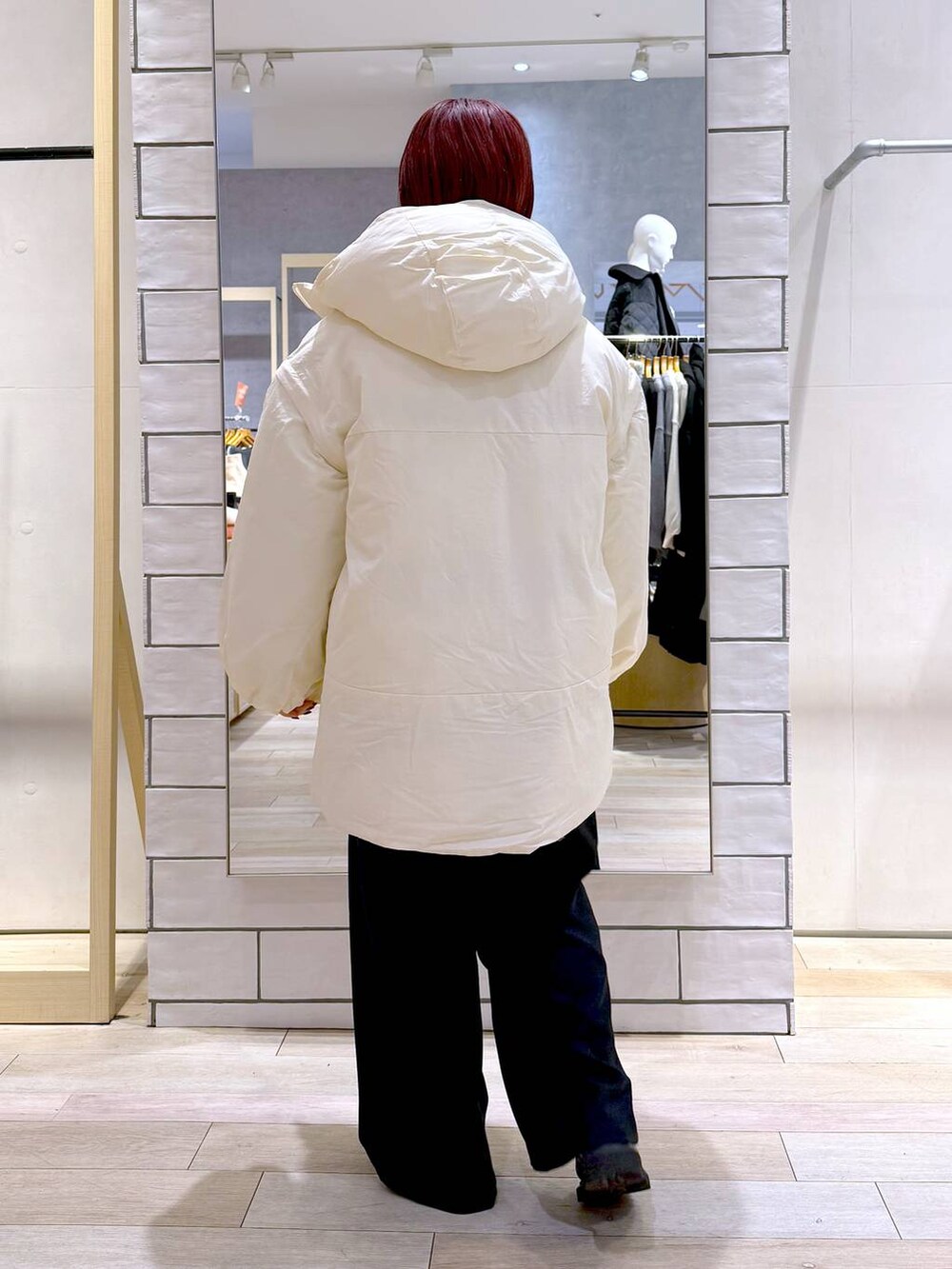 ホワイト系のその他アウター、ブラック系のその他パンツ、ブラック系のニット/セーターを着用したレディースの冬コーディネートの4枚目の写真