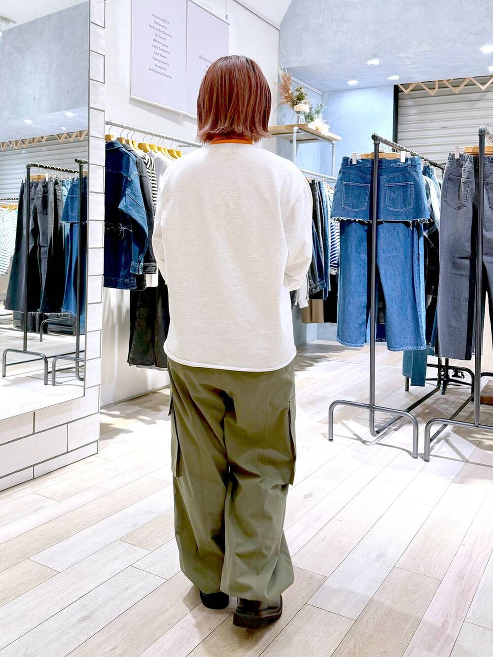 ブラック系のショルダーバッグ、オレンジ系のニット/セーター、グリーン系のカーゴパンツを着用したレディースの冬コーディネートの4枚目の写真