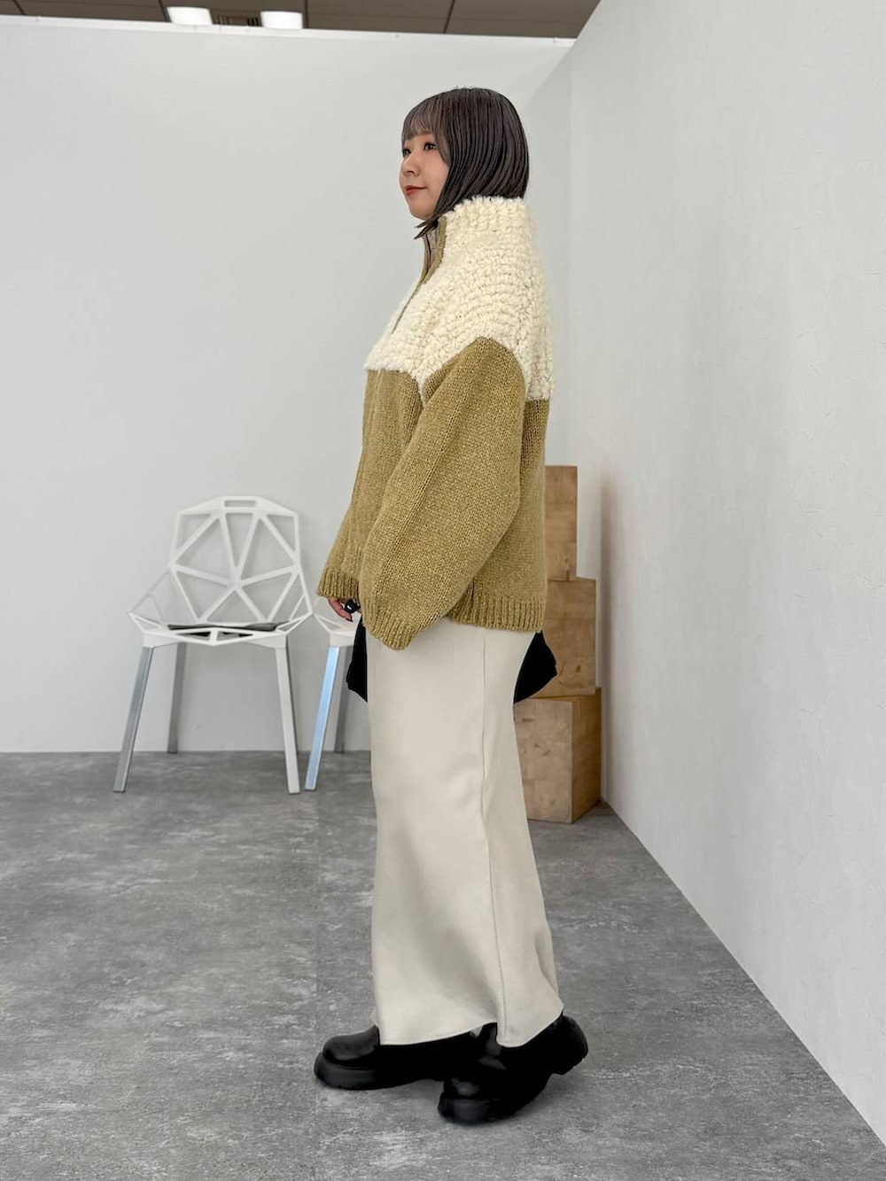 ホワイト系のスカート、ブラック系のサンダル、ブラック系のトートバッグを着用したレディースの秋コーディネートの5枚目の写真