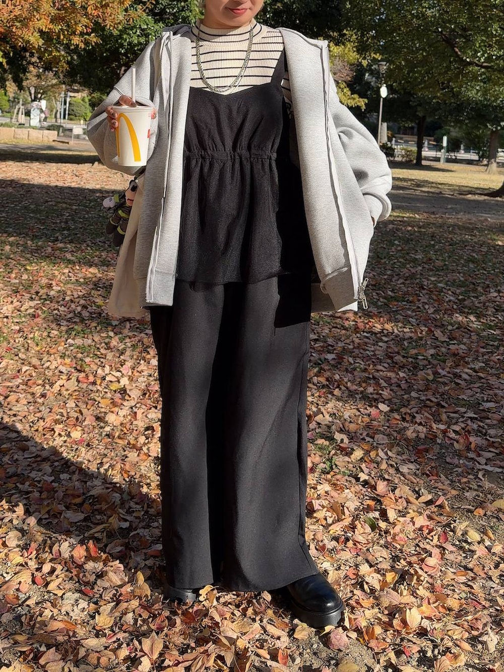 ブラック系のサンダル、ホワイト系のニット/セーター、グレー系のパーカーを着用したレディースの秋コーディネートの2枚目の写真