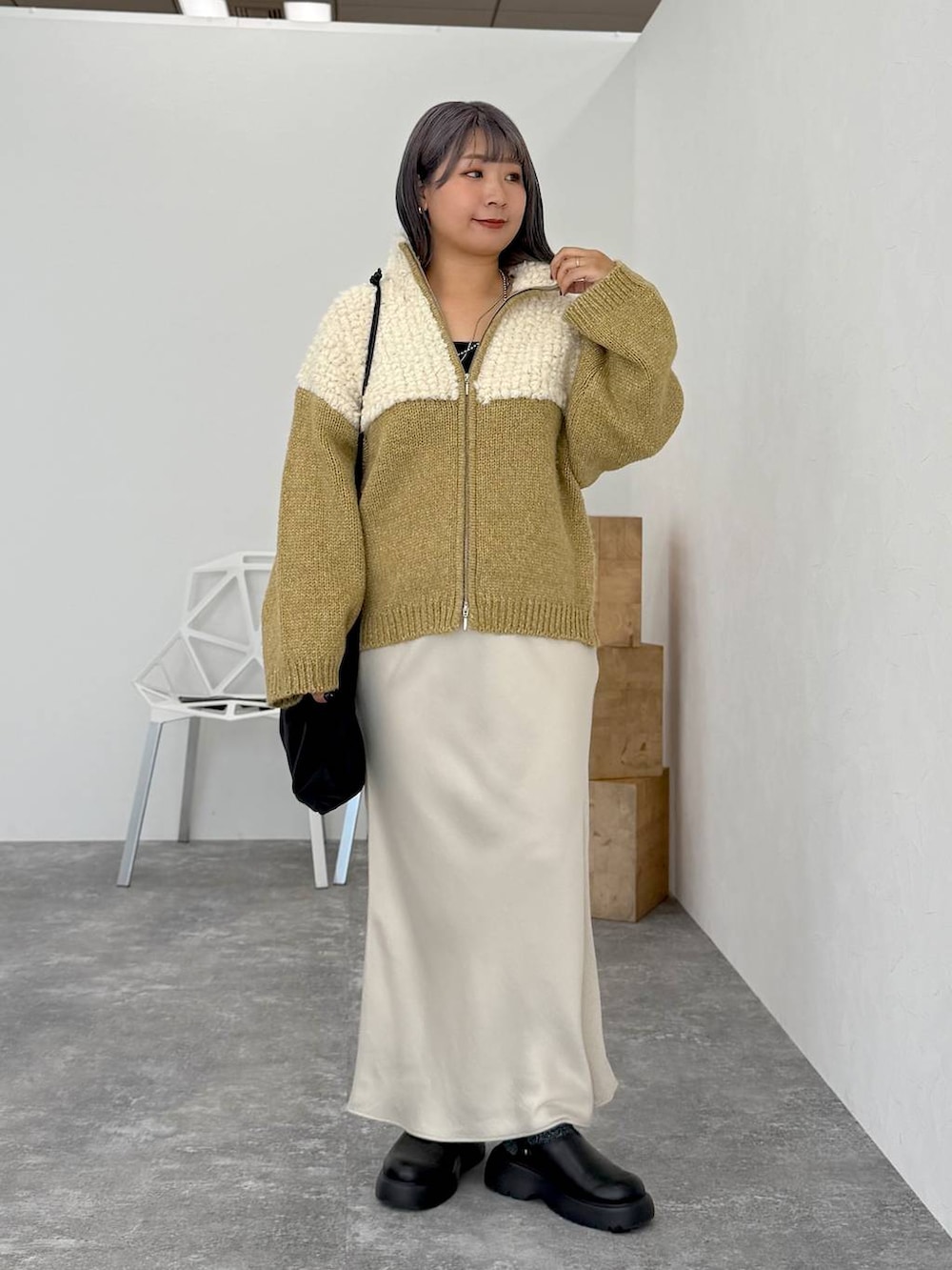 ホワイト系のスカート、ブラック系のサンダル、ブラック系のトートバッグを着用したレディースの秋コーディネートの6枚目の写真