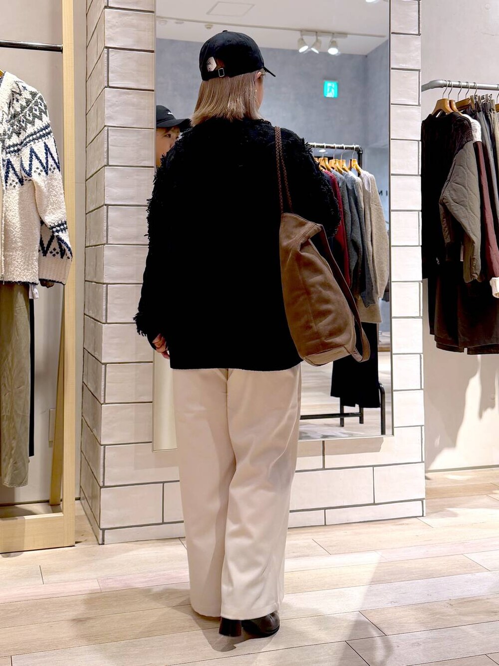 ホワイト系のその他パンツ、ブラック系のニット/セーター、ブラック系のブーツを着用したレディースの秋コーディネートの4枚目の写真