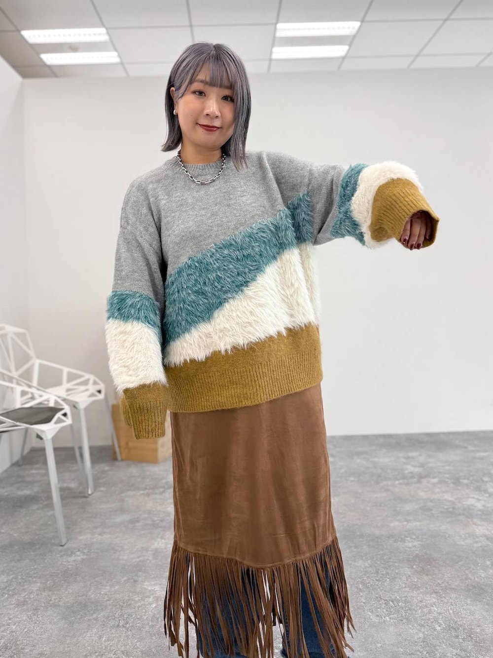 ブラック系のサンダル、イエロー系のスカート、グレー系のニット/セーターを着用したレディースの秋コーディネートの2枚目の写真