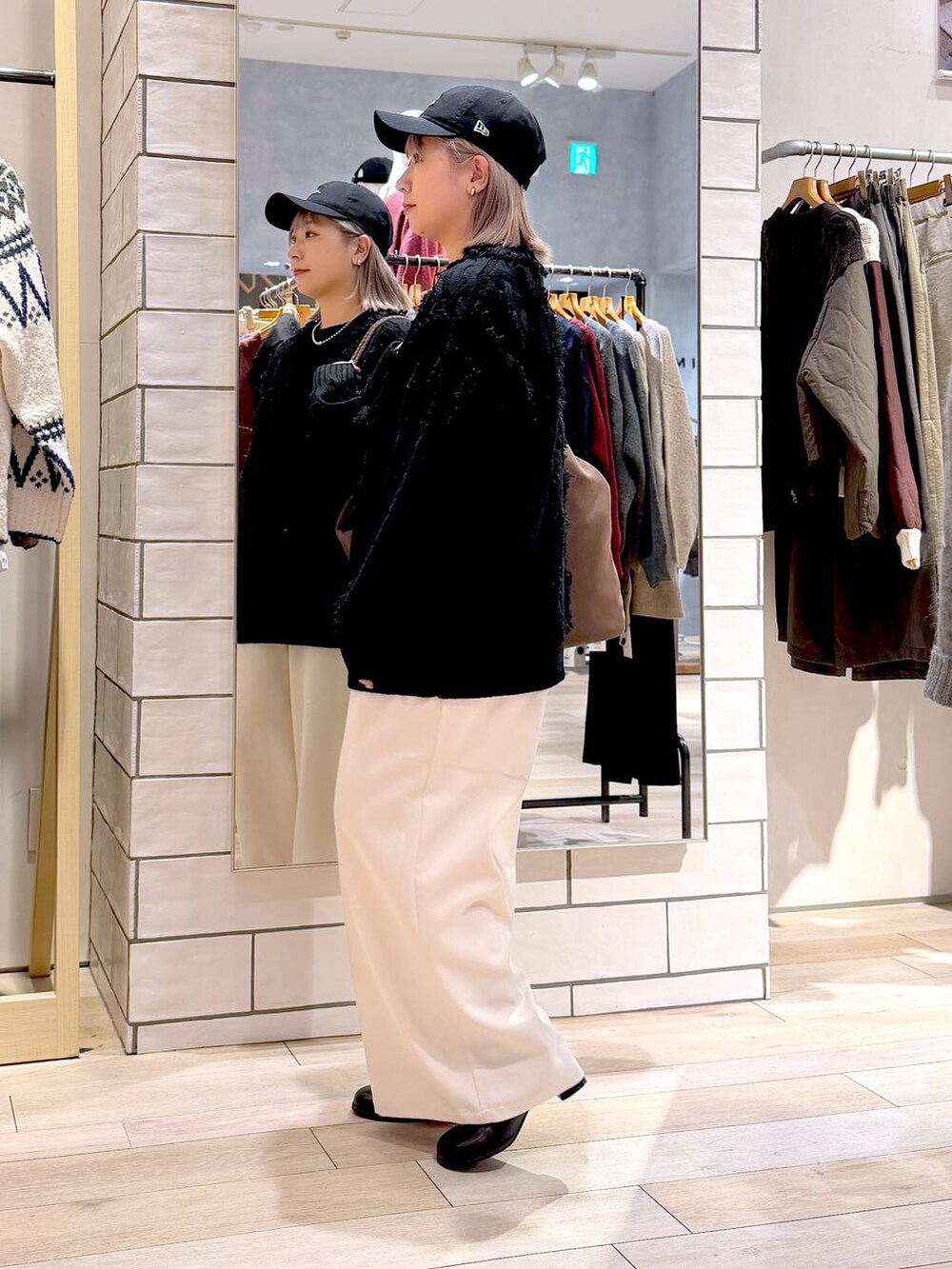 ホワイト系のその他パンツ、ブラック系のニット/セーター、ブラック系のブーツを着用したレディースの秋コーディネートの5枚目の写真
