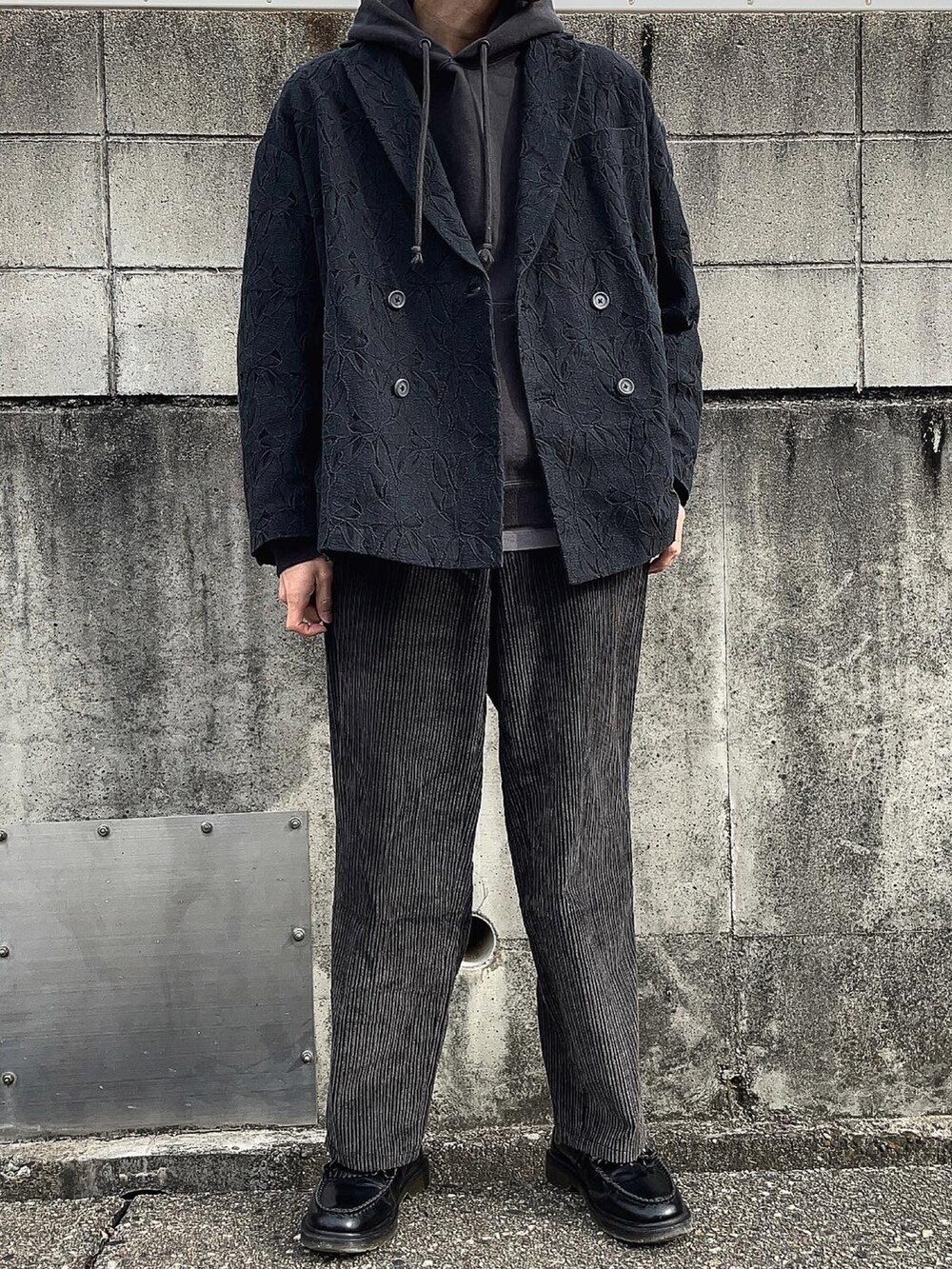 ブラック系のテーラードジャケット、ブラック系のパーカー、グレー系のTシャツ/カットソーを着用したメンズの冬コーディネートの2枚目の写真