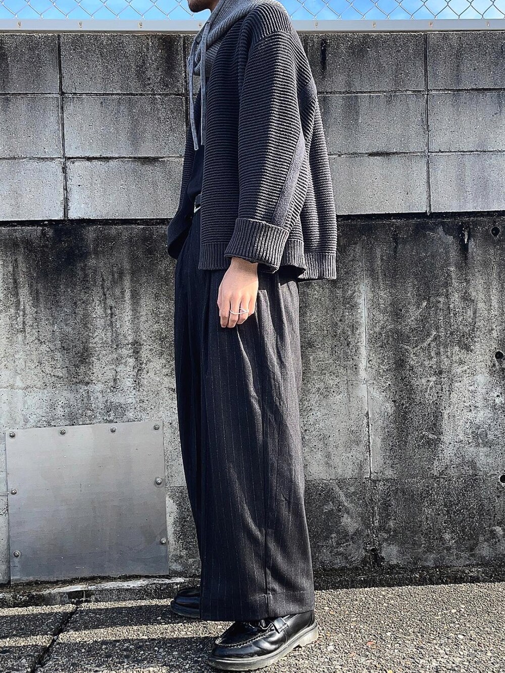 ブラック系のカーディガン/ボレロ、ブラック系のTシャツ/カットソー、ブラック系のスラックスを着用したメンズの秋コーディネートの2枚目の写真