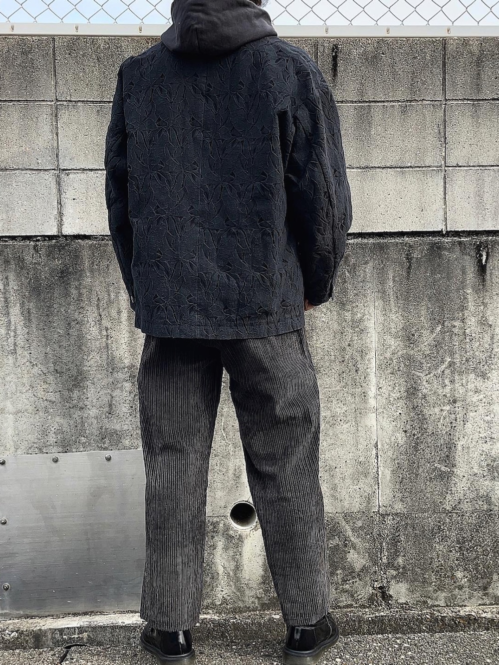 ブラック系のテーラードジャケット、ブラック系のパーカー、グレー系のTシャツ/カットソーを着用したメンズの冬コーディネートの4枚目の写真