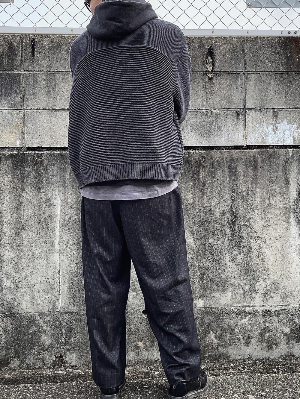 ブラック系のスラックス、ブラック系のカーディガン/ボレロ、グレー系のTシャツ/カットソーを着用したメンズの冬コーディネートの4枚目の写真