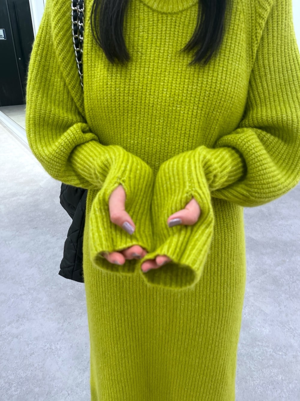 グリーン系のワンピース、ホワイト系のスニーカーを着用したレディースの冬コーディネートの2枚目の写真