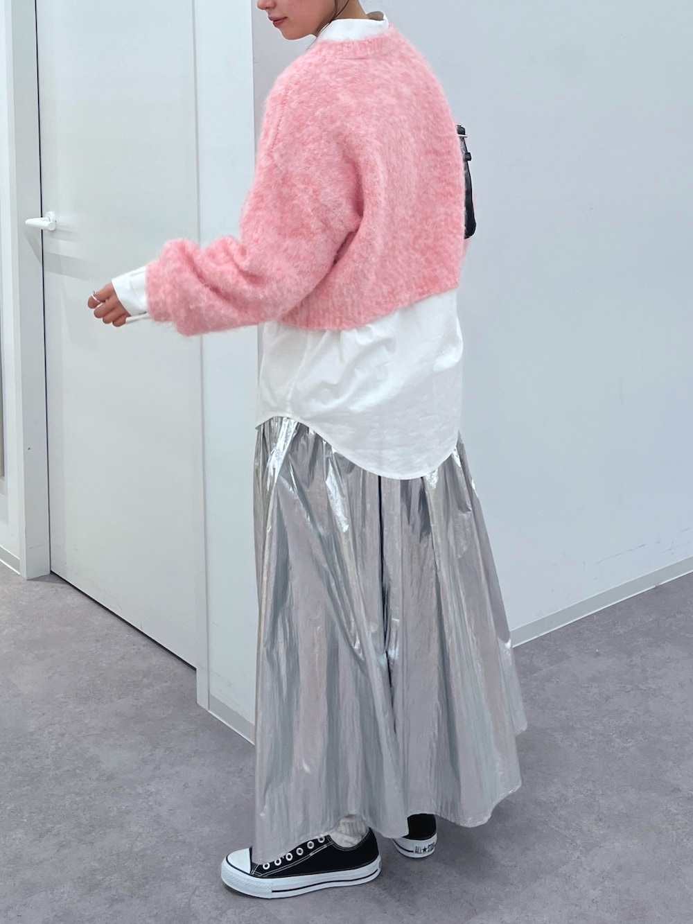 ピンク系のニット/セーター、ホワイト系のシャツ/ブラウス、シルバー系のスカートを着用したレディースの冬コーディネートの4枚目の写真