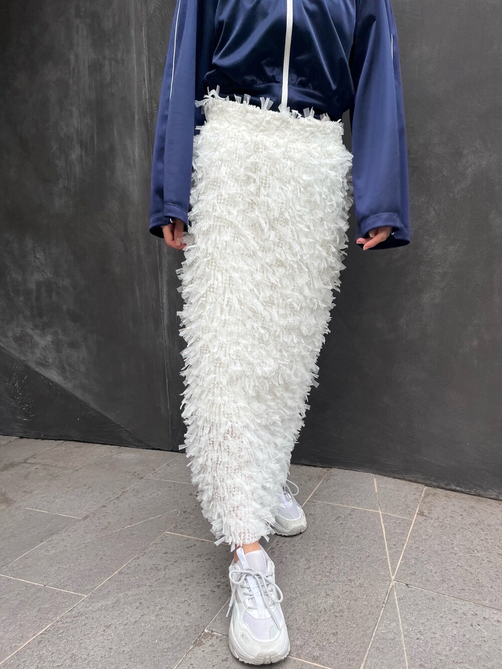 ブルー系のナイロンジャケット、ホワイト系のスカートを着用したレディースの秋コーディネートの3枚目の写真