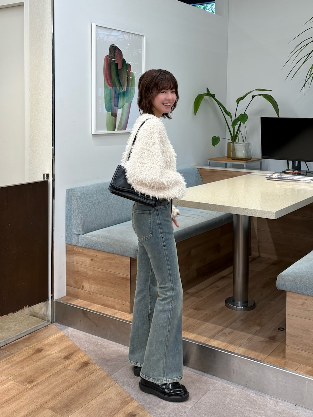 ホワイト系のスウェット、ホワイト系のデニムパンツを着用したレディースの秋コーディネートの3枚目の写真