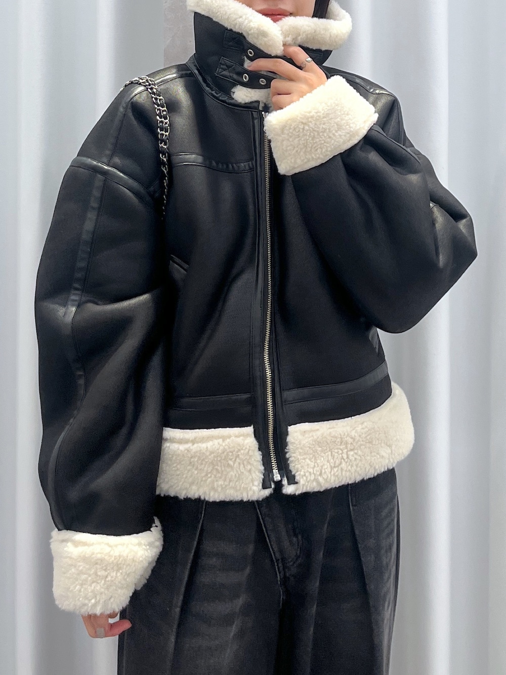 ブラック系のその他アウター、ブルー系のデニムパンツ、オレンジ系のニット/セーターを着用したレディースの冬コーディネートの5枚目の写真