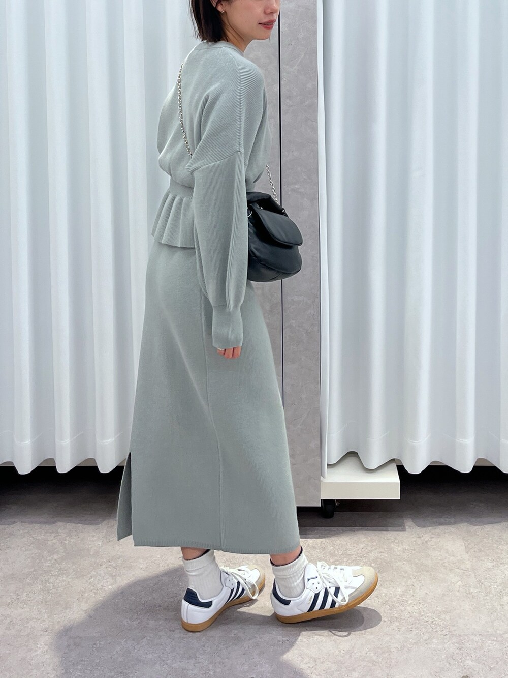 グリーン系のワンピースを着用したレディースの秋コーディネートの2枚目の写真