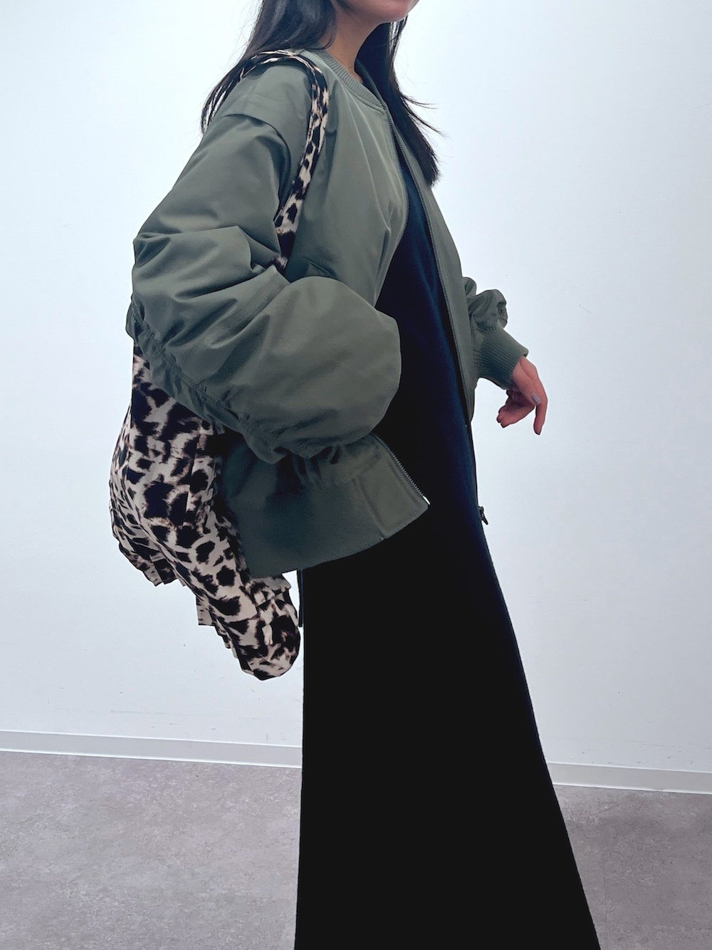 グリーン系のMA-1、ブラック系のワンピース、ブラック系のトートバッグを着用したレディースの冬コーディネートの4枚目の写真