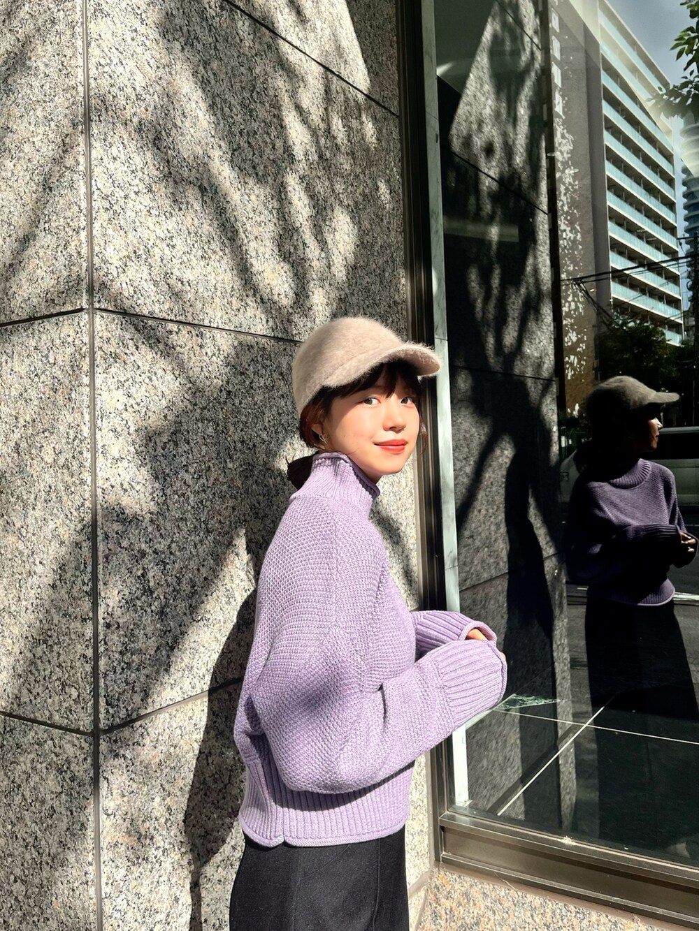 パープル系のニット/セーター、ブラック系のスカート、ホワイト系のブーツを着用したレディースの秋コーディネートの3枚目の写真