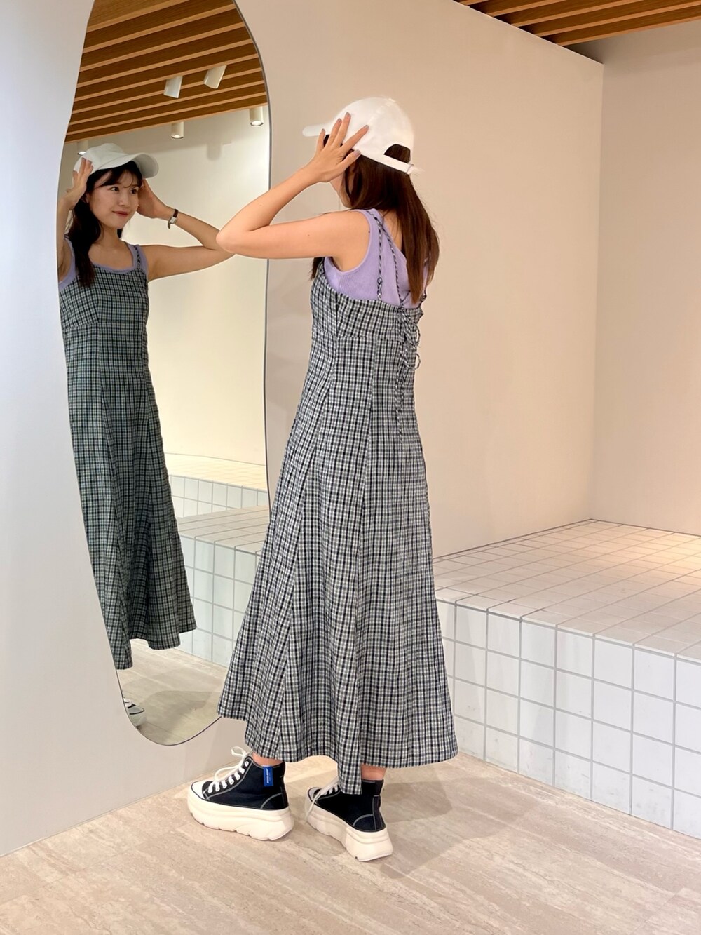 ホワイト系のワンピース、ブラック系のスニーカーを着用したレディースの夏コーディネートの2枚目の写真
