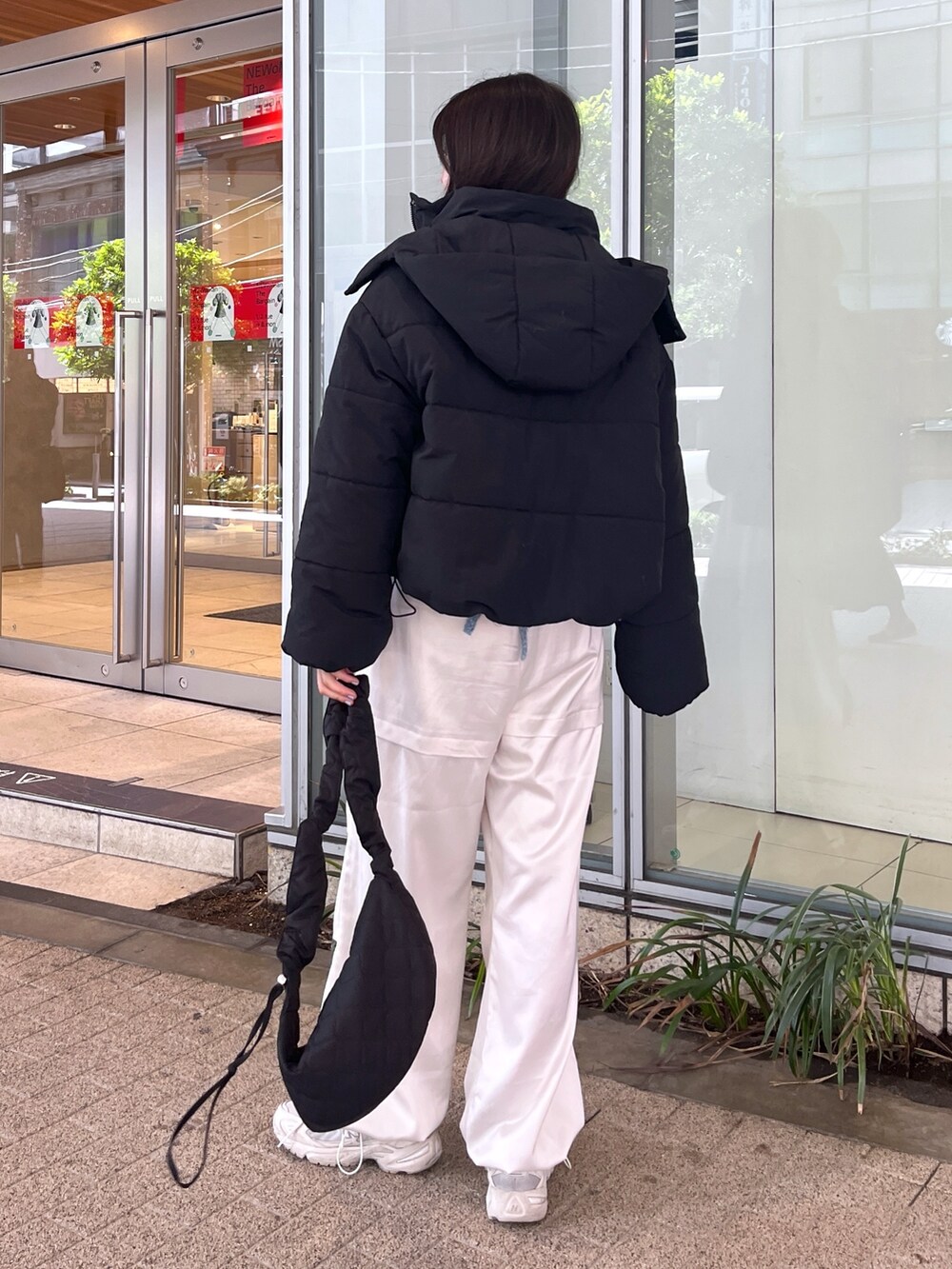 ブラック系のブルゾン、ブルー系のニット/セーター、ホワイト系のカーゴパンツを着用したレディースの冬コーディネートの3枚目の写真