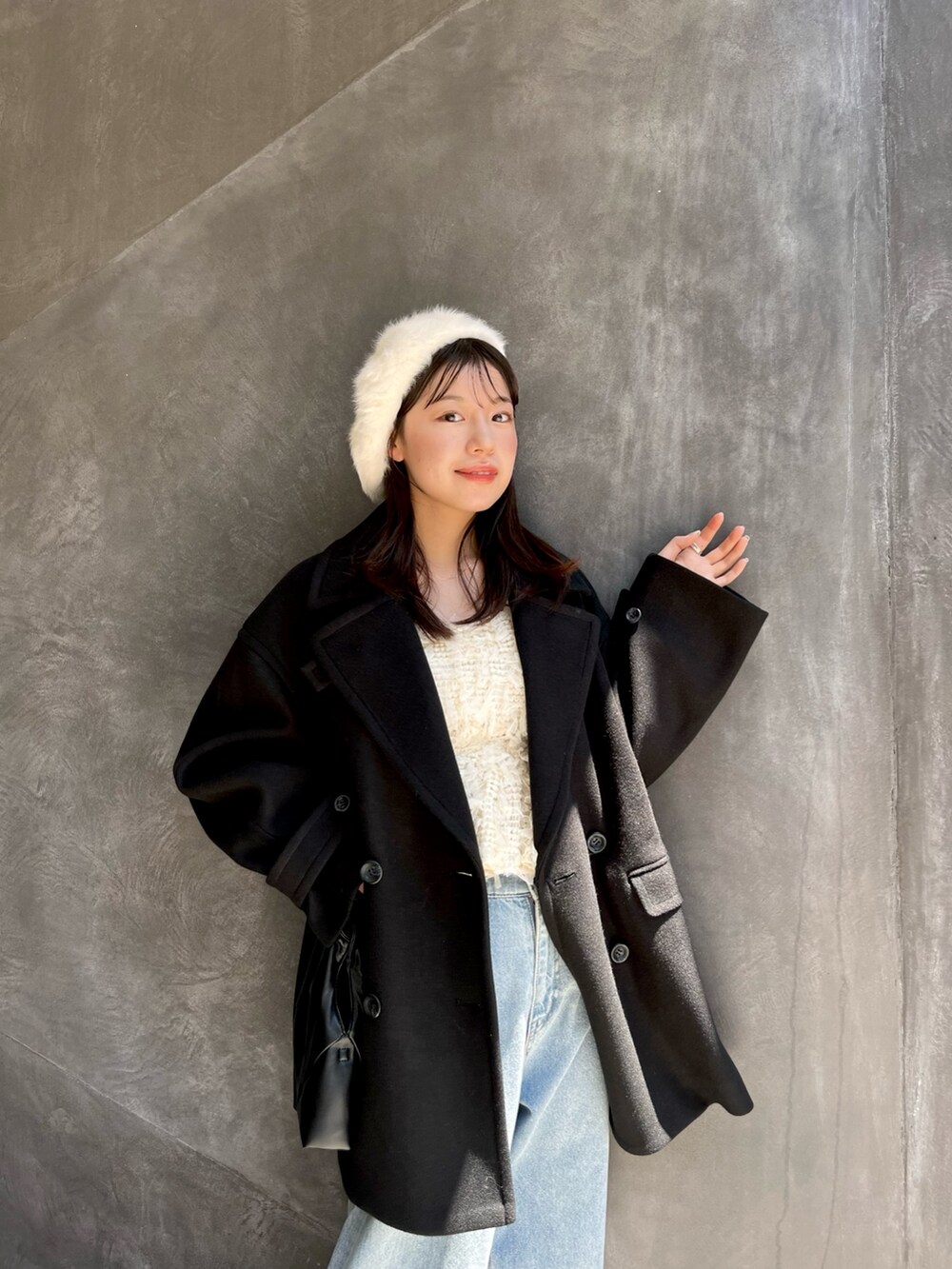 ブラック系のピーコート、ブルー系のデニムパンツを着用したレディースの夏コーディネートの3枚目の写真