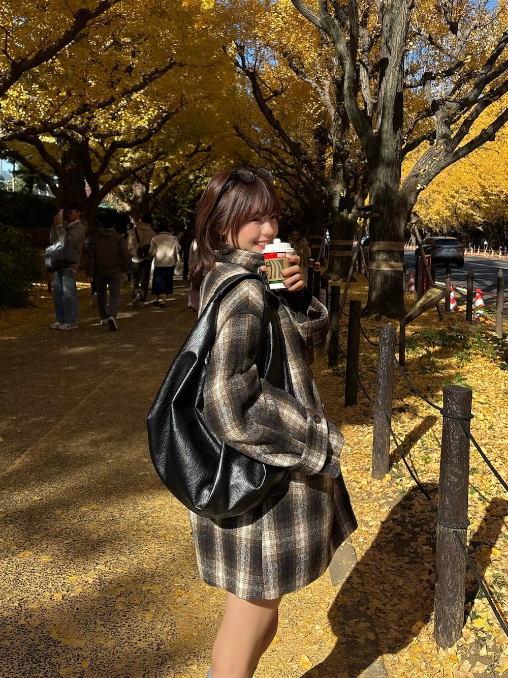 ブラウン系のピーコートを着用したレディースの秋コーディネートの2枚目の写真